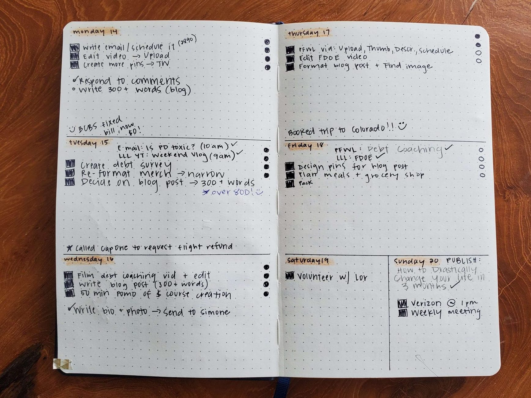 An open paper journal with a handwritten week spread